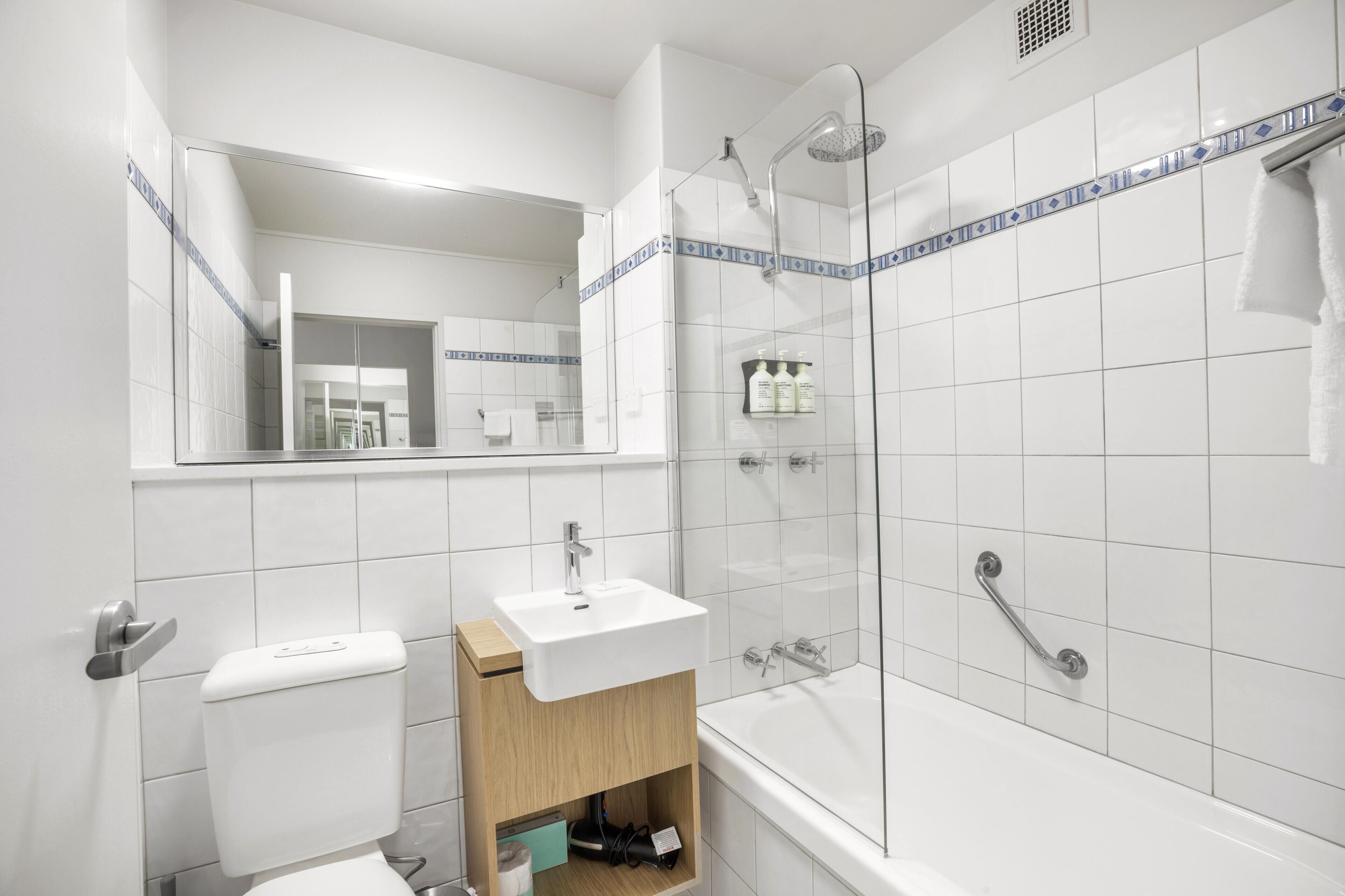 Une salle de bain moderne avec une douche à parois de verre, un lavabo blanc et des toilettes.