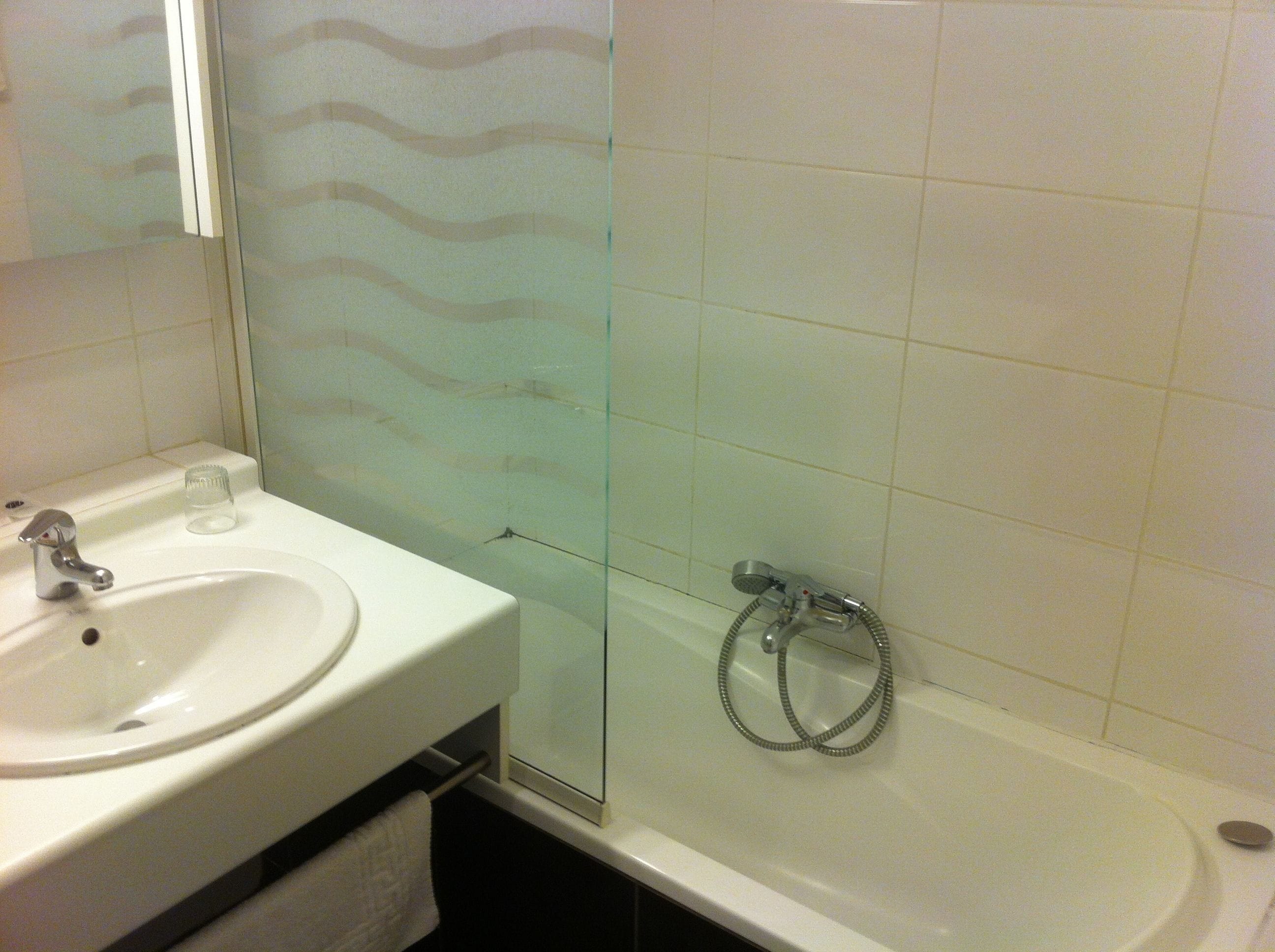 Baño con lavabo, espejo y ducha.