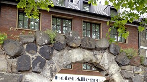 A stone archway leading to a hotel entrance with a brick facade and a sign reading "Hotel Allegro". - Hotel Allegro (Cologne)