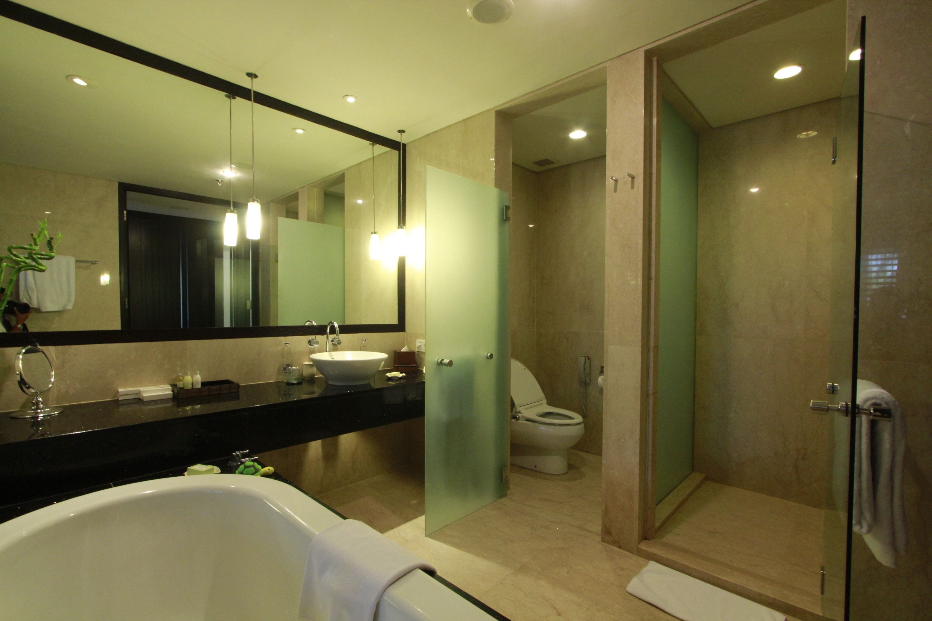 Un baño moderno con bañera, lavamanos e inodoro.
