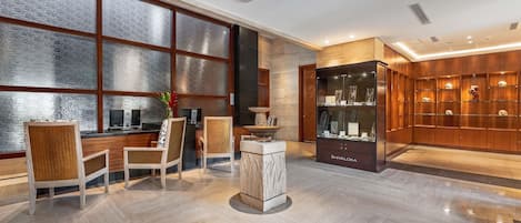 Un vestíbulo moderno con mostrador de recepción, zona de estar y una vitrina.