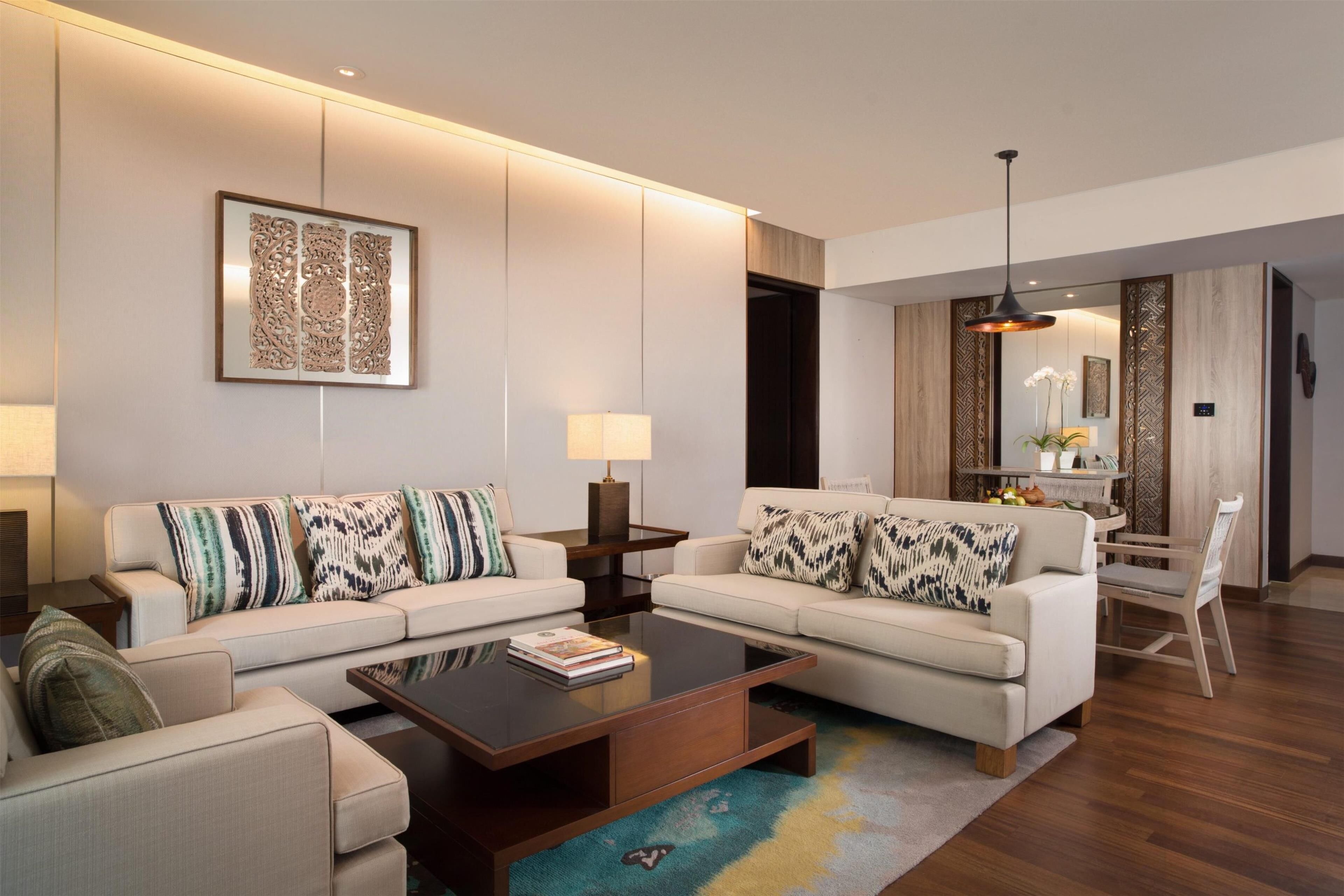 A modern living room with two sofas, a coffee table, and a dining area with a chair and table.