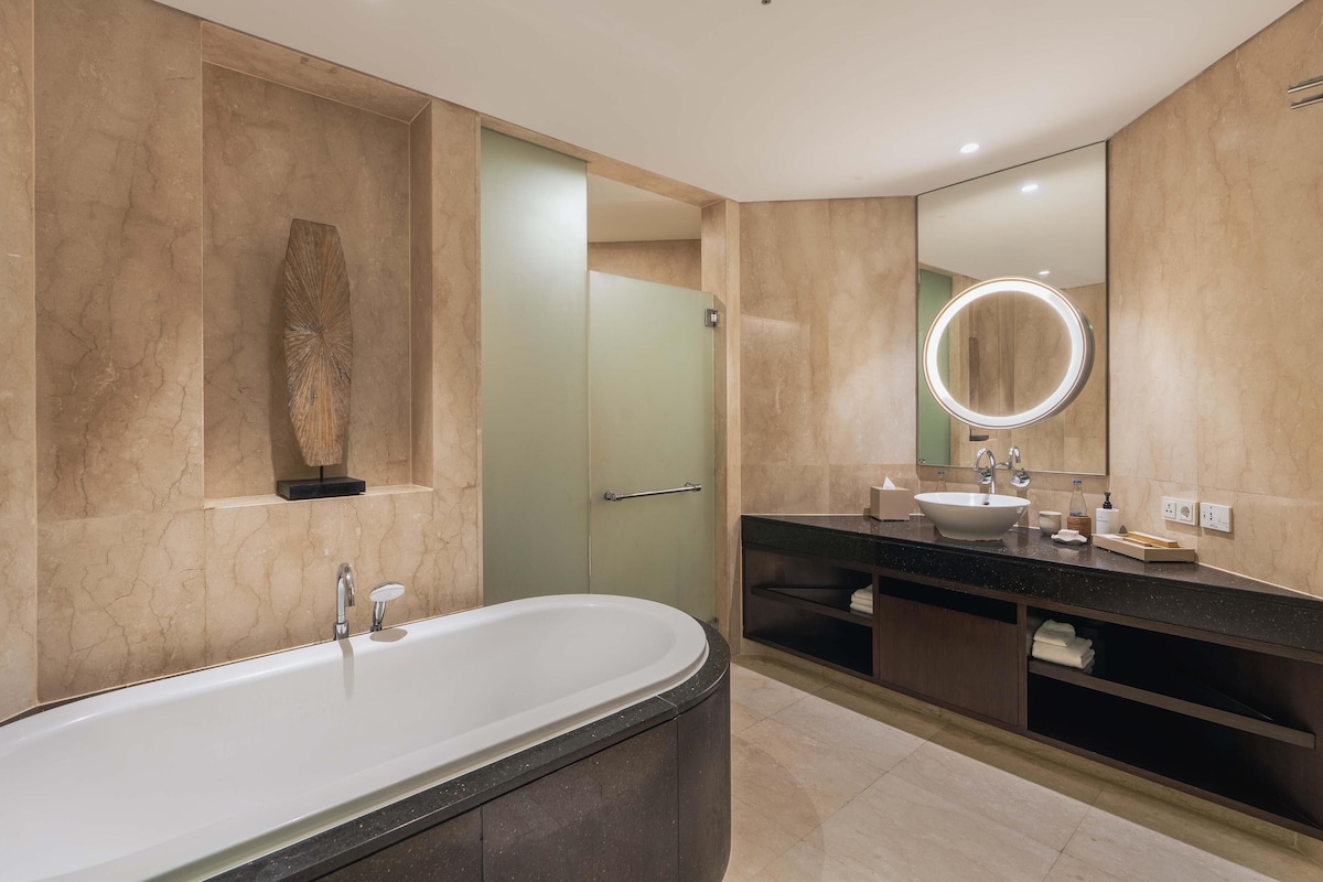 A modern bathroom with a freestanding bathtub, a vanity with a large mirror, and a minimalist design.