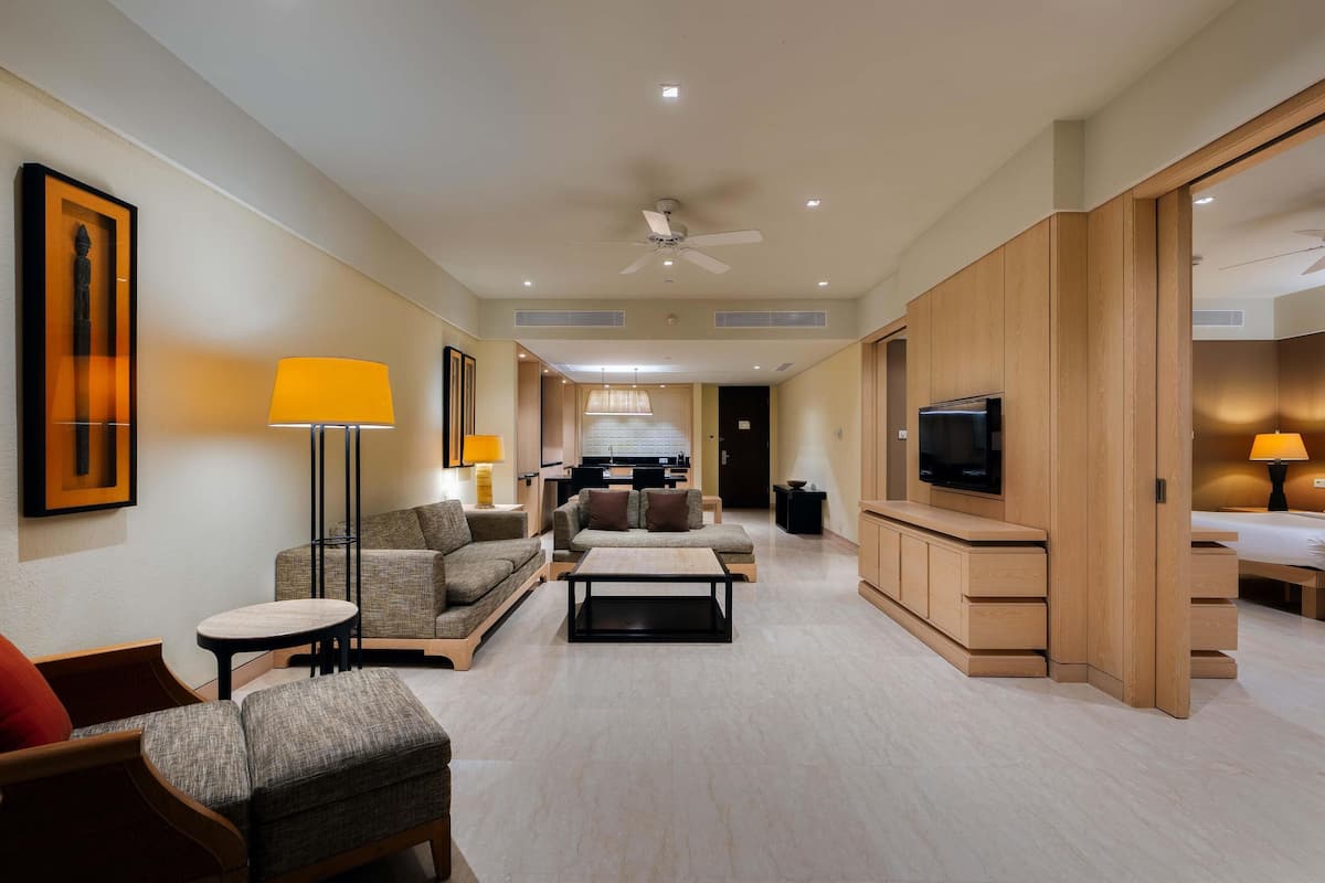 Amplia habitación de hotel con sala de estar, comedor y dormitorio.