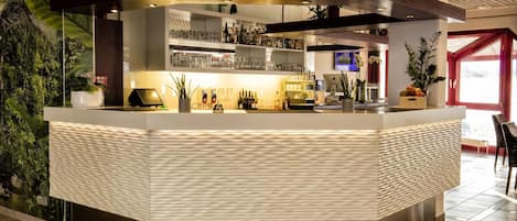 Eine moderne Bar mit einer strukturierten Theke, Regalen mit Flaschen und Topfpflanzen.