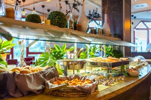 A buffet counter with various food items and a glass display case. - LOFTSTYLE Hotel Gerlingen, Sure Hotel Collection by B/W (Gerlingen)