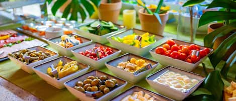 Un bufé con diversos alimentos dispuestos en bandejas.