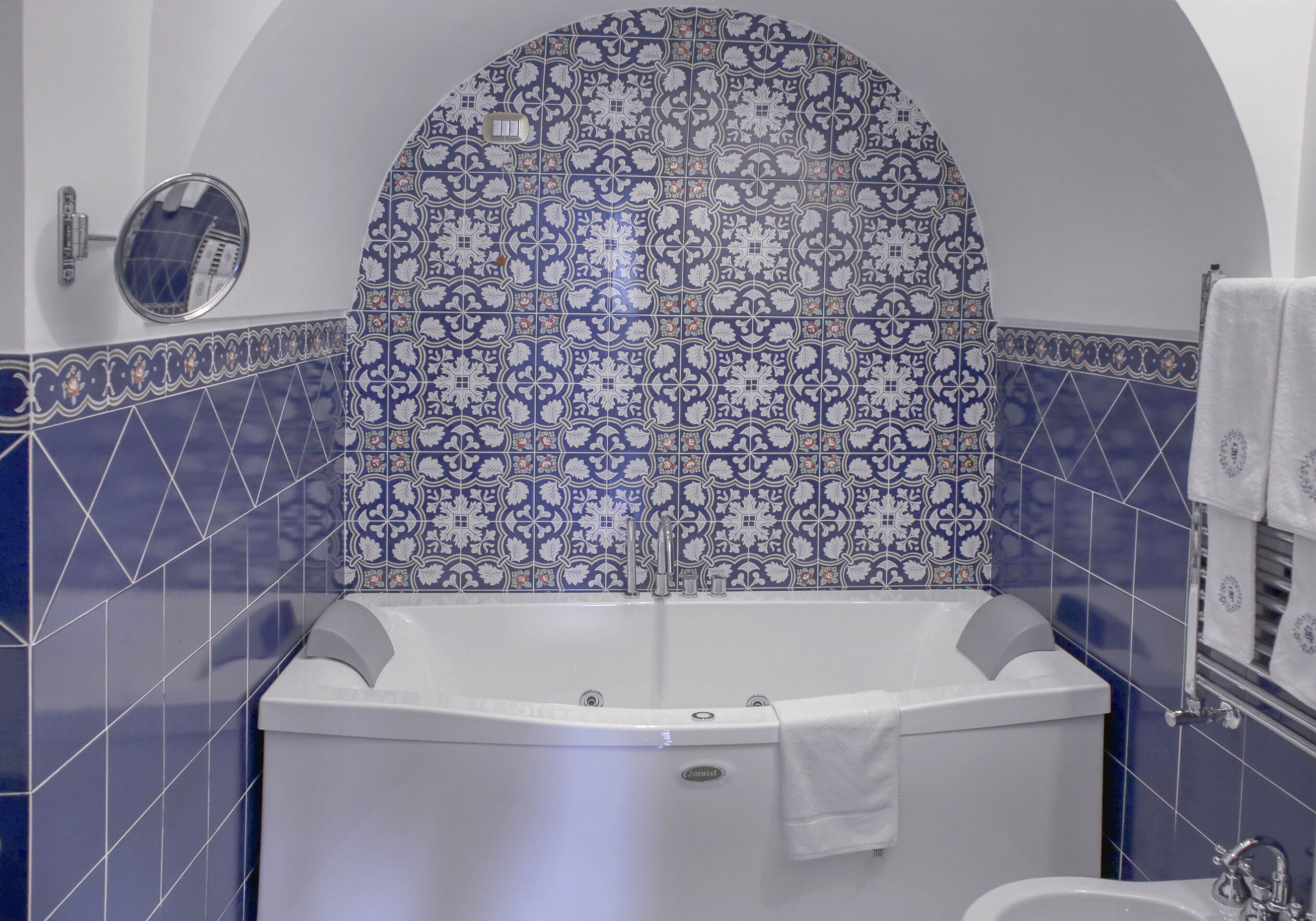 A bathroom with a freestanding bathtub, a mirror, and a towel rack.