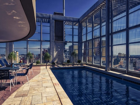 Una piscina al aire libre, sillones reclinables de piscina