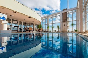 Una piscina al aire libre, sillones reclinables de piscina
