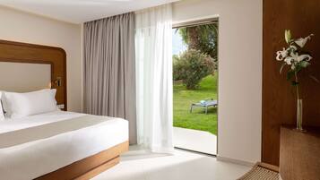 A hotel room with a bed, a view of the garden, and a chair.