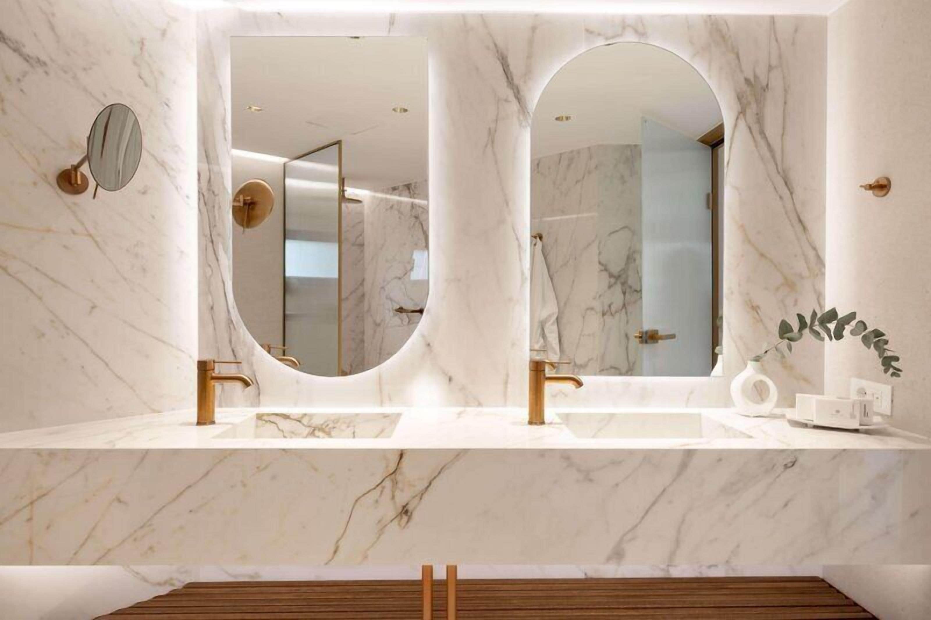 A bathroom with two sinks, a large mirror, and a wooden vanity.