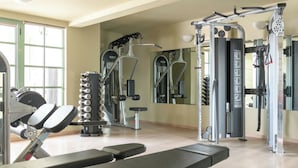 A gym with exercise equipment, a bench, and a mirror.