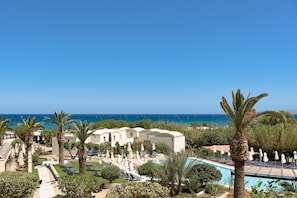 A resort with a pool, palm trees, and a view of the sea. - Agapi Beach Resort - Premium All Inclusive (Malevizi)