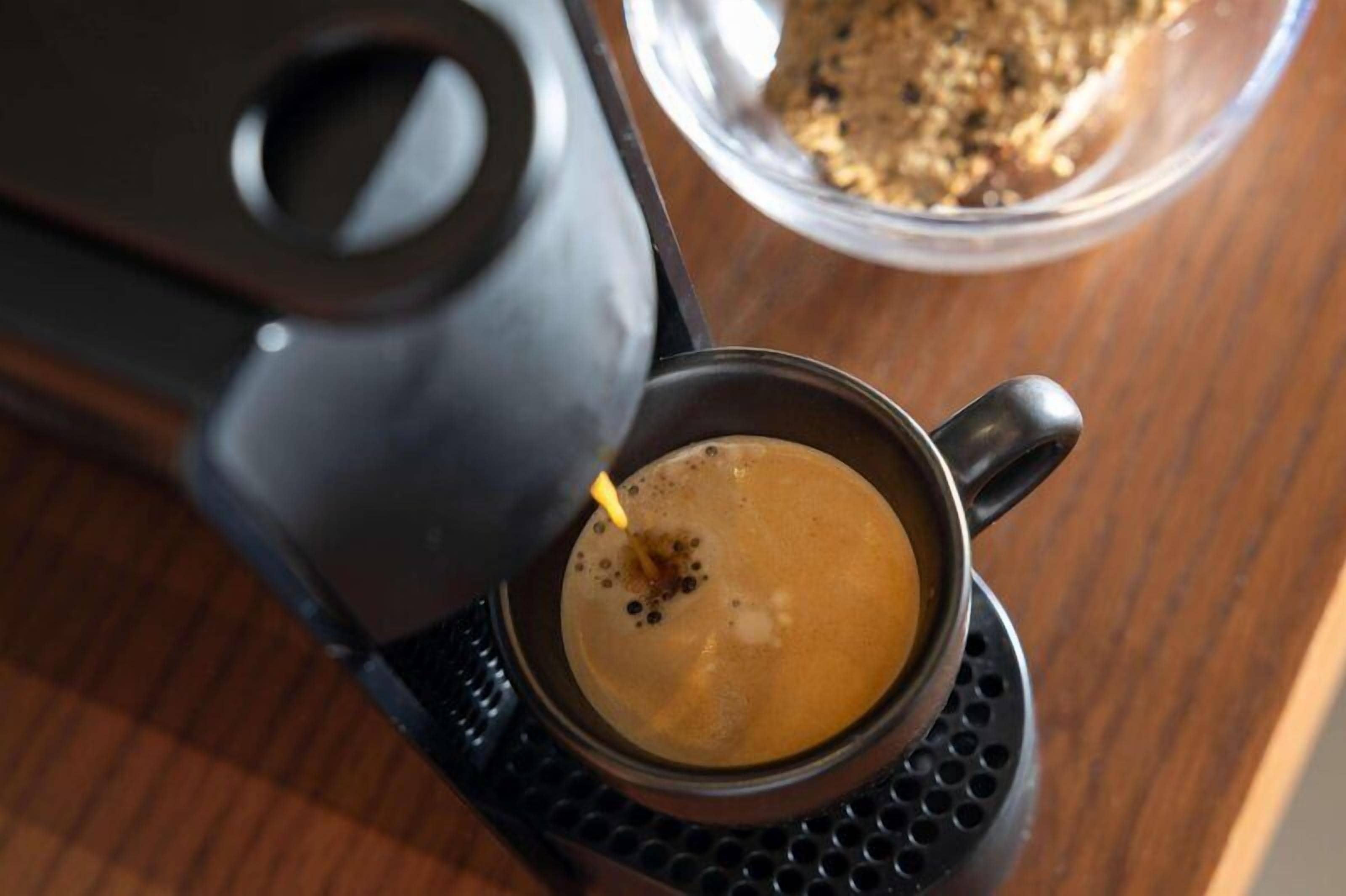 A coffee machine dispensing coffee into a cup.