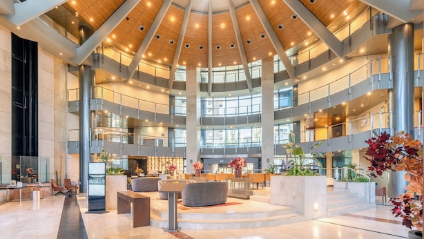 Un'ampia hall con zona salotto centrale, diversi livelli e un design moderno.