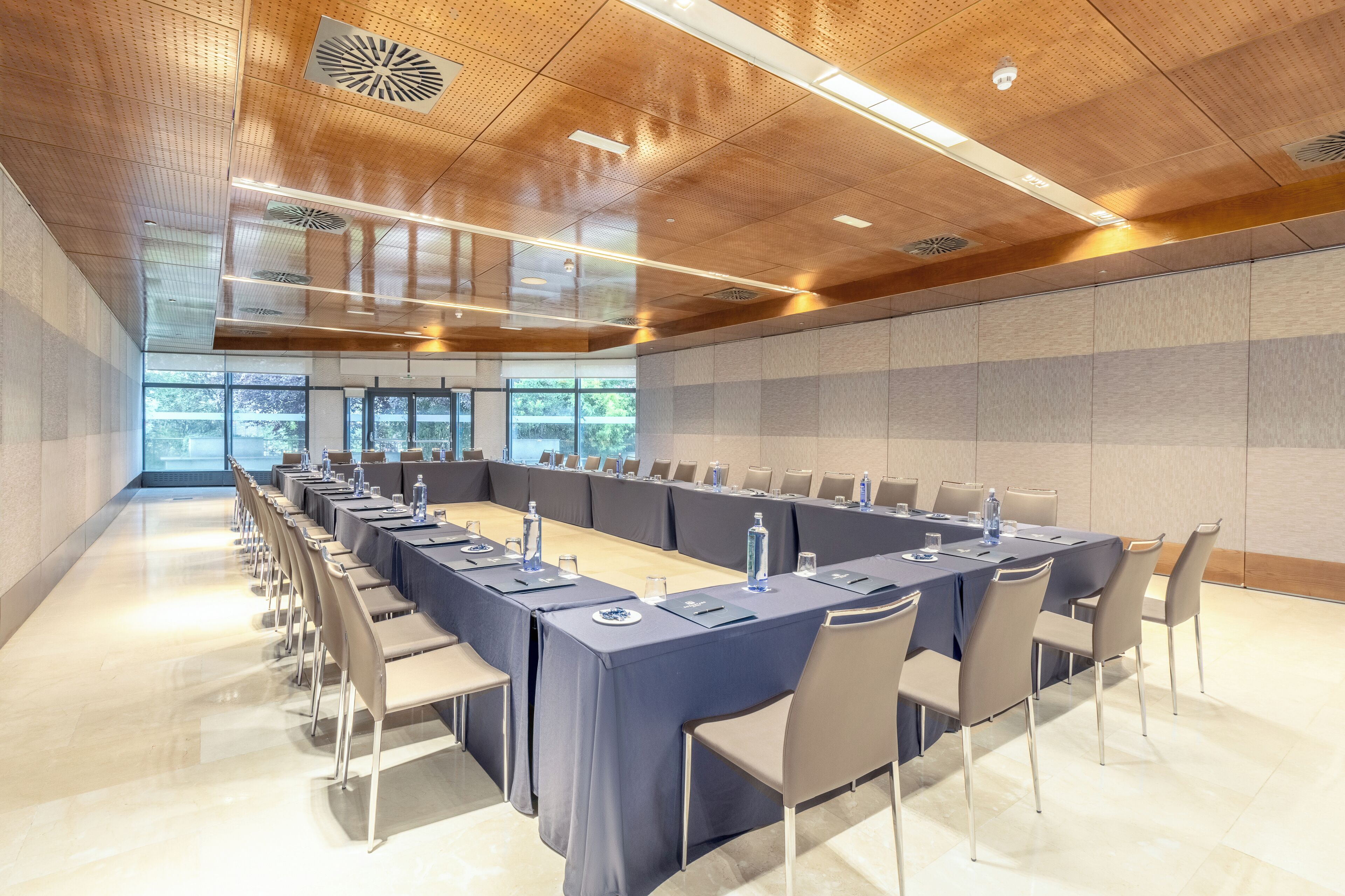 A conference room with a long table, chairs, and a modern ceiling design.