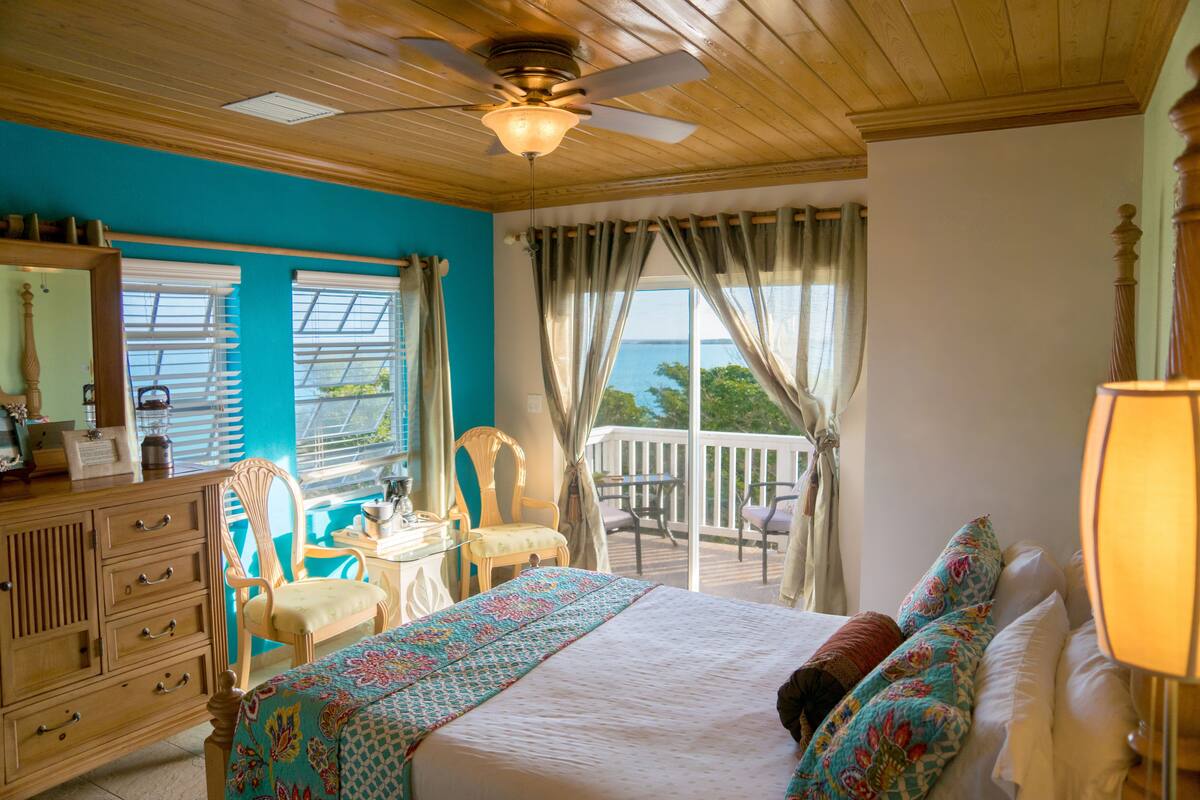 Un dormitorio con cama, cómoda y balcón con vistas.