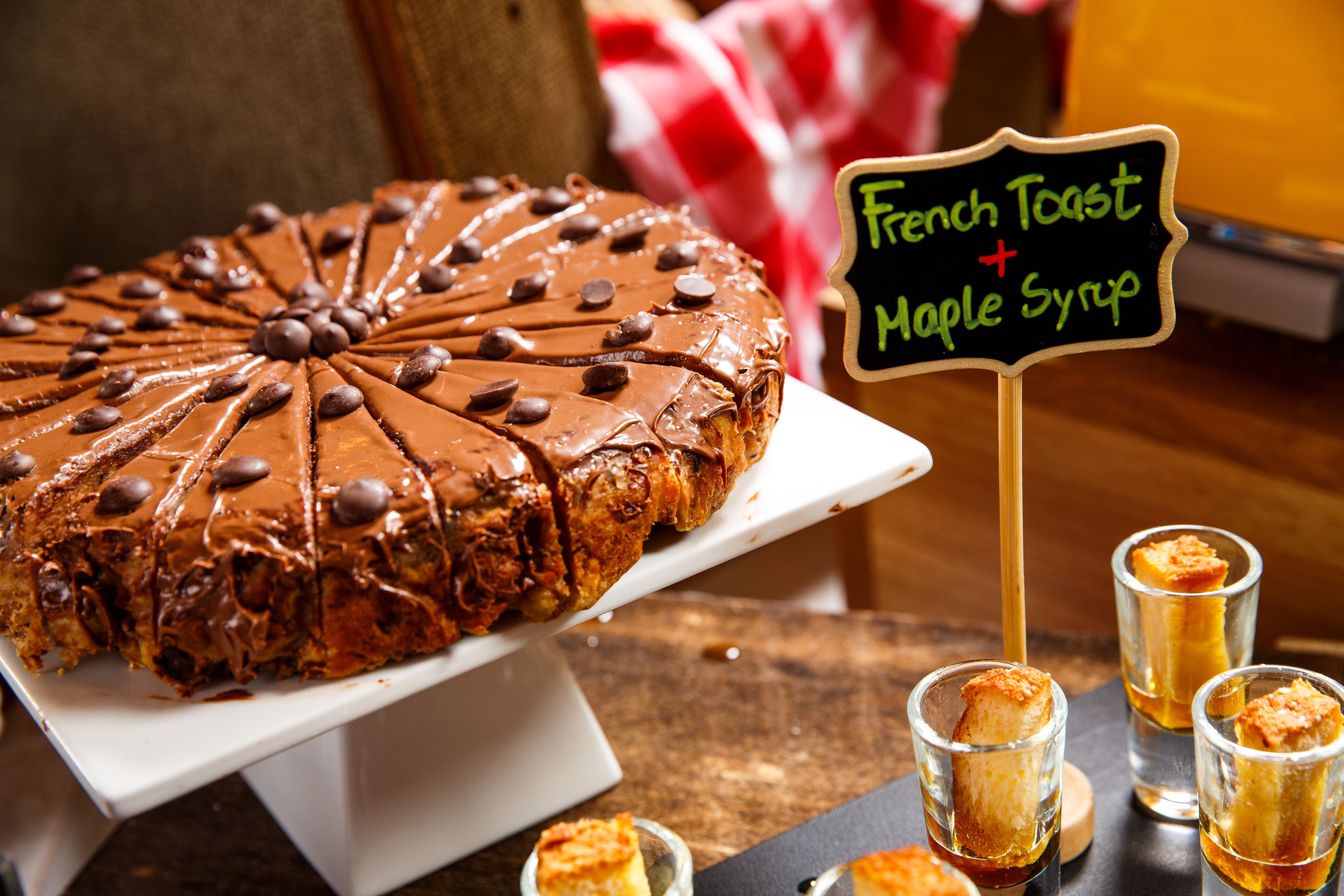 Un pastel de chocolate grande con un letrero que indica que es tostada francesa con jarabe de arce.
