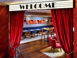 A restaurant with a 'WELCOME' sign, red curtains, and a neon 'SHOWTIME' sign. - ibis Styles London Southwark – near Borough Market (London)