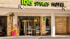 L’extérieur de l’hôtel ibis Styles se distingue par sa façade moderne, son grand hall d’entrée vitré et une décoration rouge et or qui invite à la découverte.