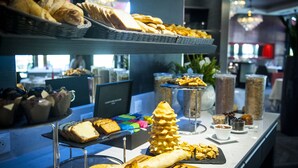 A buffet with various food items including bread, pastries, and desserts.