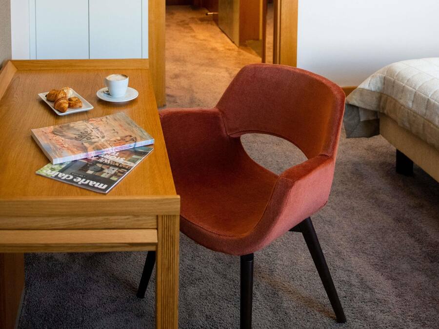 Une table en bois avec un magazine, une tasse de café et des croissants.