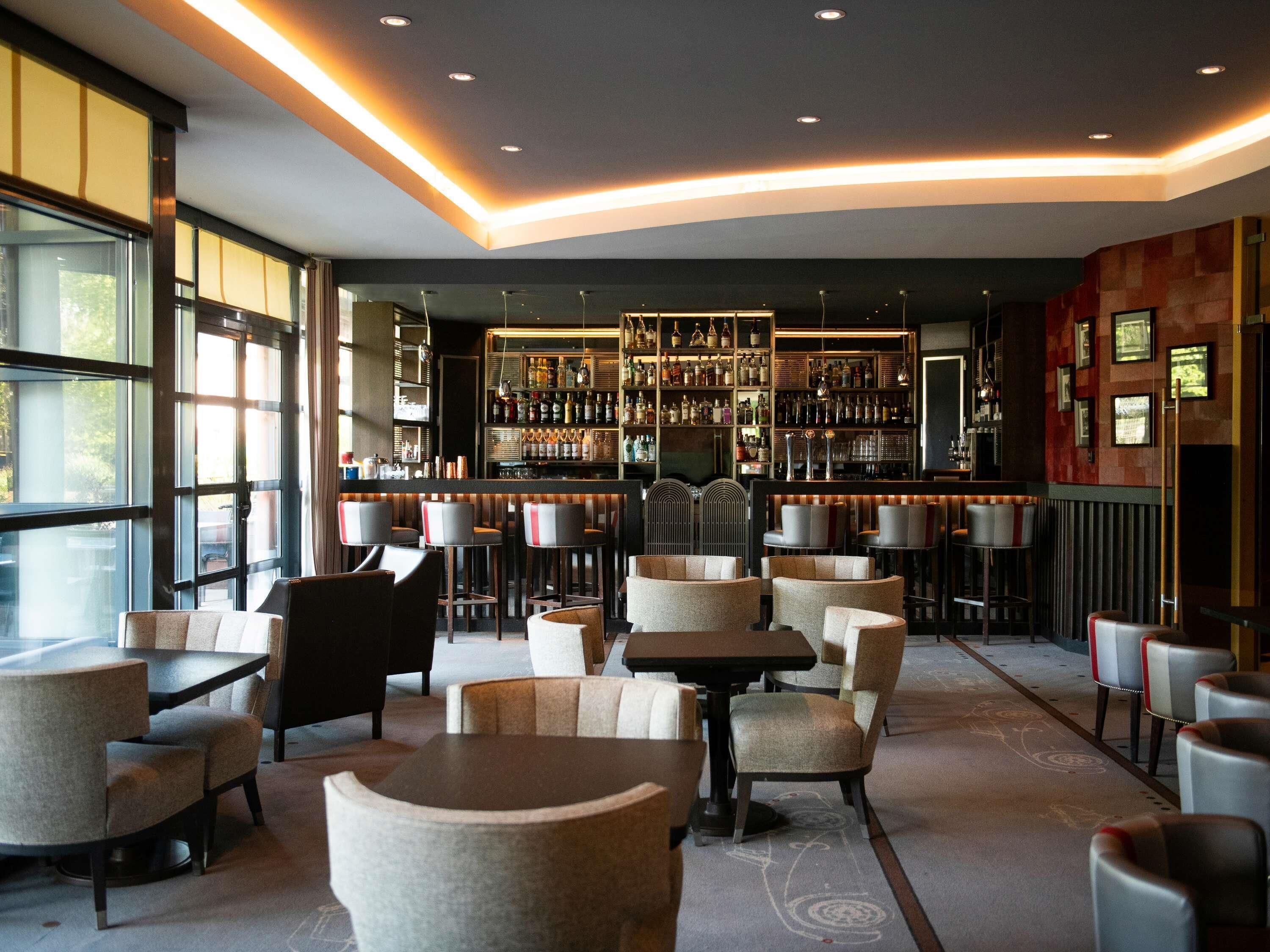 A bar area with multiple seating options and a well-stocked bar counter.