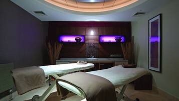 Relax in this serene space with two massage tables and a reception area featuring a counter and sink.