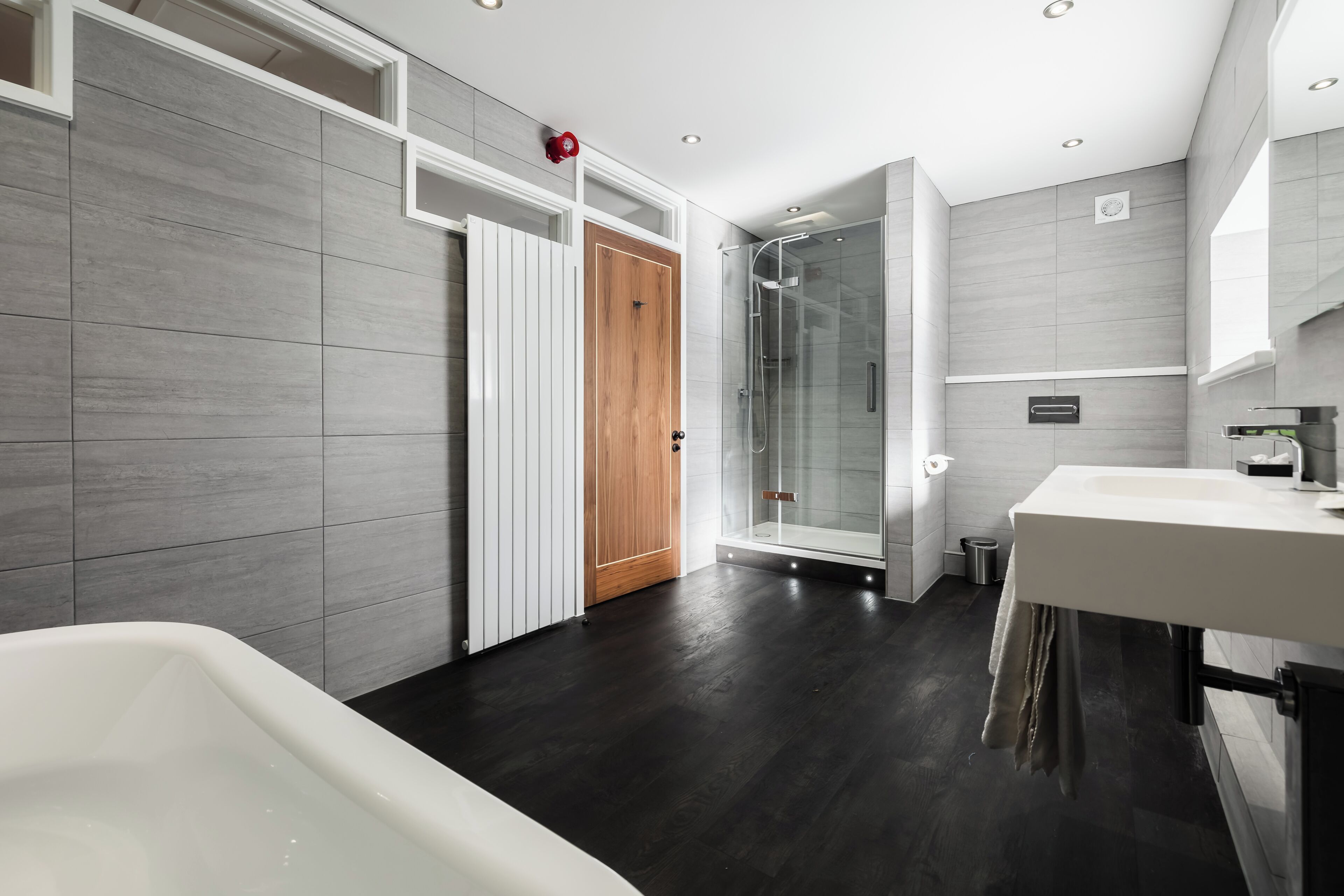 A modern bathroom with a bathtub, shower, and vanity.