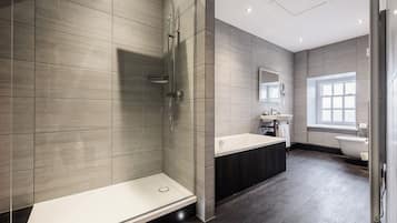 A modern bathroom with a shower, sink, and toilet.