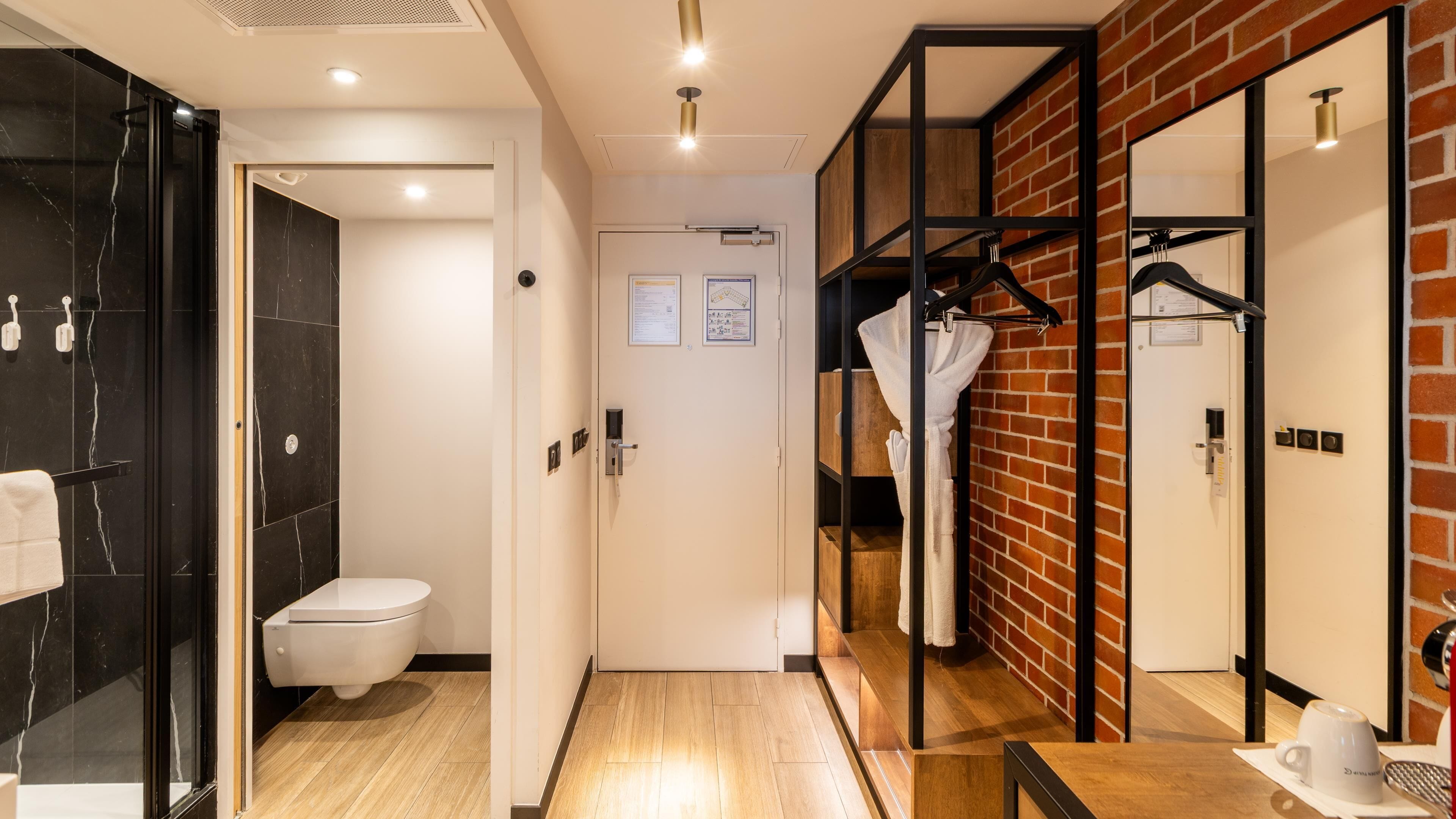 A modern bathroom with a toilet, a mirror, and a shower area.