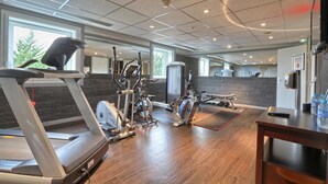 Un gimnasio con cintas de correr, elípticas y pesas sueltas.