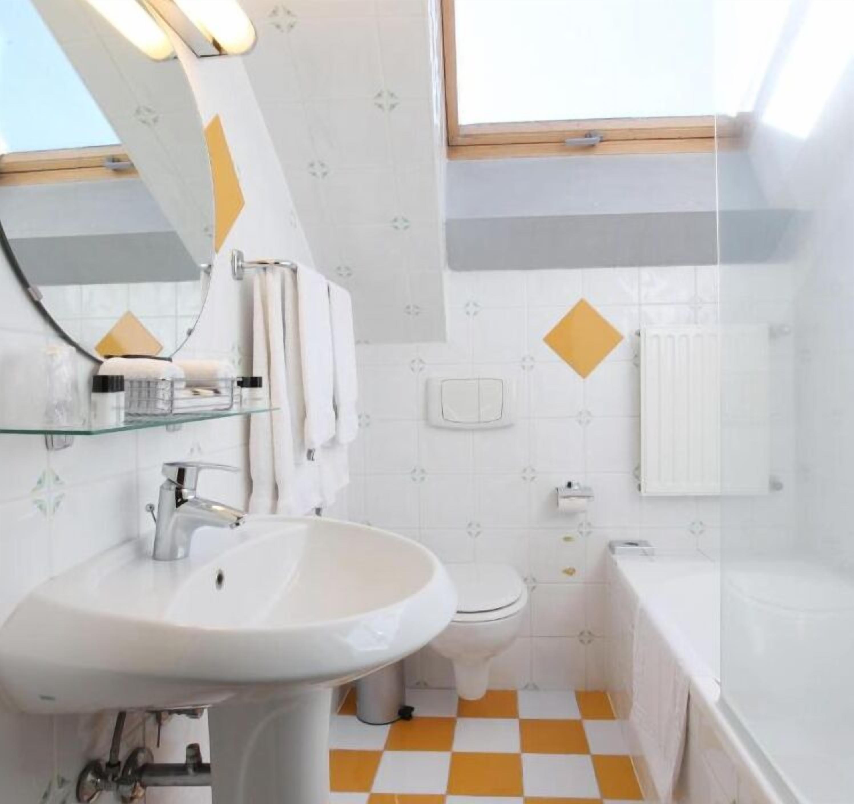 Un baño con lavamanos, inodoro y bañera.