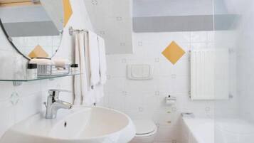A bathroom with a sink, toilet, and bathtub.