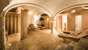 A spa area with stone flooring, wooden furniture, and arched ceilings.