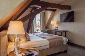 A hotel room with a bed, a desk, a lamp, and a TV. - Dukes’ Arches – by Dukes’ Hotel Collection (Bruges)