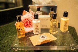 A display of L'OCCITANE and JASMIN Bergamotet perfume bottles on a glass counter.
