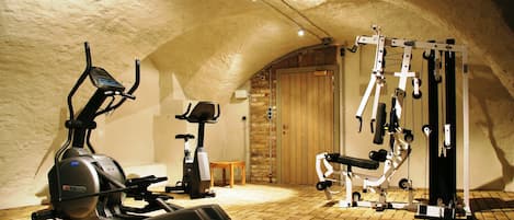A gym with exercise equipment including a stationary bike, elliptical, and a multi-functional workout machine.