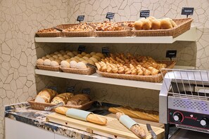 A bakery display with various breads and pastries. - Hotel Aragon (Bruges)
