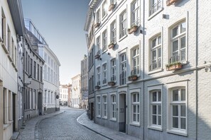 Stroll through historic streets lined with classic European architecture, featuring buildings with multiple stories and charming flower boxes.