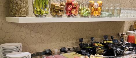 A buffet with various food items and a selection of fruits and vegetables.