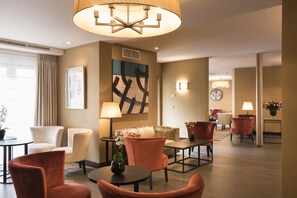 Relax in our inviting lobby, featuring comfortable seating, a statement art piece, and a stunning chandelier.