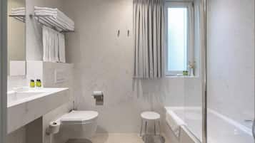 Une salle de bain moderne équipée de toilettes, d’un lavabo et d’une baignoire.