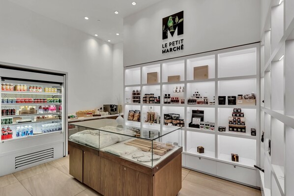 Un espacio comercial limpio y moderno, con una sección refrigerada a la izquierda y una exhibición de diversos productos a la derecha.