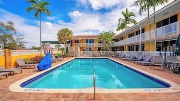 Una piscina al aire libre, sombrillas, tumbonas