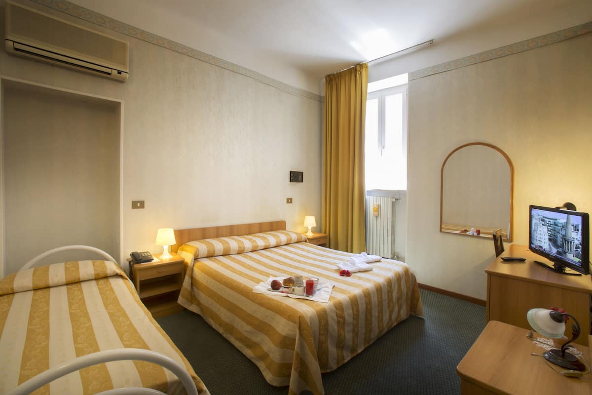 Driepersoonskamer | Een kluis op de kamer, een bureau, verduisterende gordijnen, babybedden