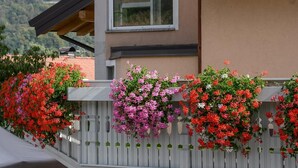 A building with a white picket fence adorned with hanging flower baskets.