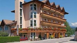 A multi-story hotel with balconies and a central entrance.