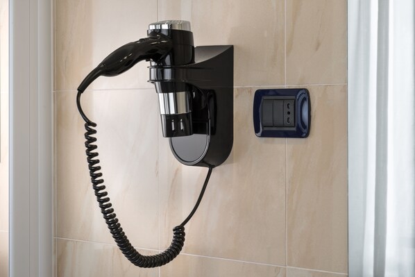 Un téléphone fixé au mur, doté d’un fil enroulé.